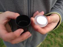 Tip the Alka seltzer into water half-filling the cannister