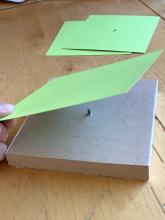 Using a template to punch holes in cardstock (before class)