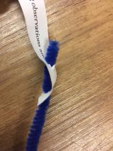 Fastener between paper and pipe cleaner