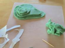 Sequentially stack up the play dough shapes to make a mountain, their positions determined by a copy of the contour line map