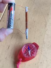 Electromagnet attracts compass needle