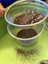sieving to separate larger marbles and gravel from the other materials