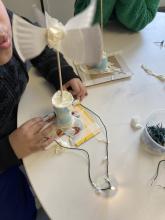 Student trickily lights a bulb from behind their wind spinner to mimic a wind turbine in action